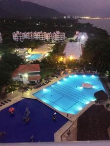 una vista aérea de una gran piscina por la noche en Costa Azul Suites 403 en Santa Marta