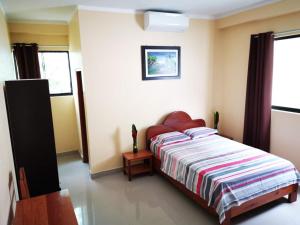 塔拉波托的住宿－Hostal Cordillera Azul，一间卧室配有带条纹被子的床