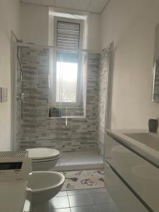 a bathroom with a shower and a toilet and a sink at Casa vacanze nonna Prassede Alloggio incantevole in casa indipendente .. in Lecco