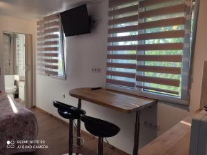 a room with a table and two stools in front of a window at Apartment Albert parking privé gratuit in Limoux