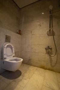 uma casa de banho com um WC e um chuveiro em شاليه خاص em Riyadh