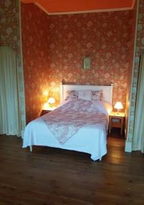 um quarto com uma cama grande e papel de parede vermelho em Château de Lacenne em Sembas