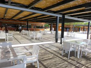 a patio with white chairs and tables and a building at TALYA TURİZM TATİLEVLERİ ve VİLLALARI in Belek