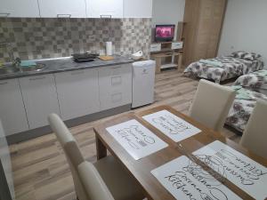 a kitchen and dining room with signs on a table at Apartman Zivanovic in Foča