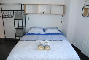 Una cama con dos pares de zapatillas. en Studio Nancy quartier Thermal - Parc Sainte-Marie en Nancy