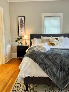1 dormitorio con 1 cama grande y toallas. en Black and white cottage; Simple yet stunning., en Joplin