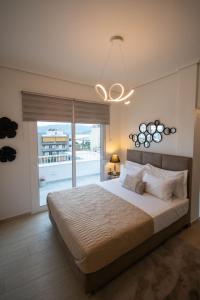 a bedroom with a large bed and a large window at Sea View luxury apartment in Volos