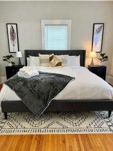 1 dormitorio con 1 cama grande y edredón negro en Black and white cottage; Simple yet stunning., en Joplin