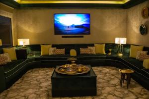 a living room with a couch and a flat screen tv at شاليه خاص in Riyadh