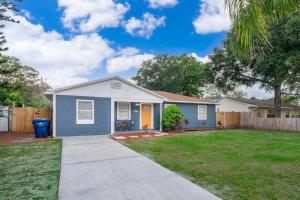 a small blue house with a fence in a yard at Forever Summer - Entire House! with KING Bed! in Clearwater