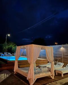 a bed sitting next to a swimming pool at night at Pool Garden-Oaza in Skopje