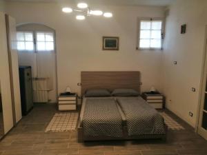 1 dormitorio con 1 cama, 2 mesas y 2 ventanas en LOFT AZZURRA, en Cannobio
