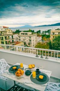 a table with two plates of food on a balcony at Sea View luxury apartment in Volos