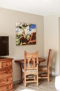 a dining room table with a chair and a television at Aarchway Inn in Moab