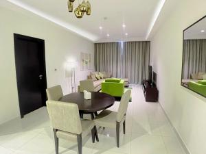 een eetkamer met een tafel en stoelen en een bank bij Lovely one bedroom apartment with world class hotel amenities in Dubai