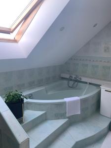 a bathroom with a bath tub in a attic at Apartament Krokusowa in Rumia