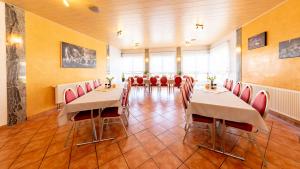 松德斯豪森的住宿－Pension & Gaststätte Zur Salzgrube，用餐室配有桌子和红色椅子
