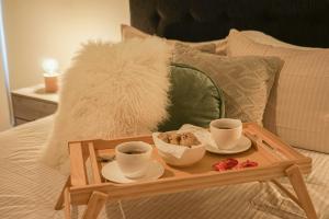 a wooden tray with two cups of coffee on a bed at Chic Executive Apartment-Barranco in Lima