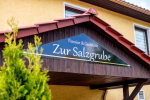un letrero para un saludo zur en un edificio en Pension & Gaststätte Zur Salzgrube, en Sondershausen