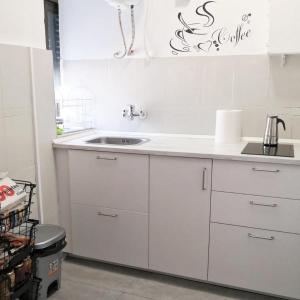 a kitchen with white cabinets and a sink at Vivienda rural Minas Home in Olleros de Sabero