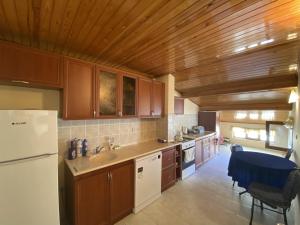 a kitchen with a white refrigerator and wooden ceilings at Balcı Apart in Çanakkale