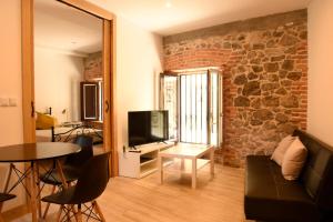 a living room with a couch and a television at Apartamentos Tierra y Arte in Santoña
