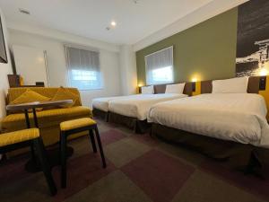 a hotel room with two beds and a chair at Henn na Hotel Tokyo Haneda in Tokyo