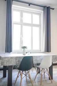 een eettafel met 2 stoelen en een raam bij Apartament "Przy Dworcu" in Chojnice
