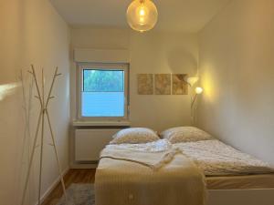 ein kleines Schlafzimmer mit einem Bett und einem Fenster in der Unterkunft NEU: Grüne Idylle nahe Hauptbahnhof & Hufeisensee in Halle an der Saale