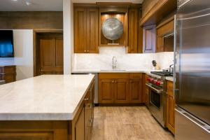 uma cozinha com armários de madeira e electrodomésticos de aço inoxidável em Luxury One Bedroom with Hot Tub apartment hotel em Park City