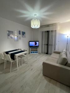 sala de estar con sofá, mesa y TV en APPARTAMENTO VACANZE A 300mt dal mare!, en Silvi Paese