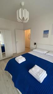 Un dormitorio con una cama azul con toallas. en APPARTAMENTO VACANZE A 300mt dal mare!, en Silvi Paese