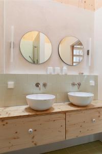 two sinks on a counter in a bathroom with mirrors at Noorderbed in Amsterdam +15 photos
