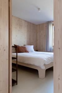 sypialnia z łóżkiem z drewnianą ścianą w obiekcie Noorderbed w Amsterdamie