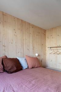 Cama en habitación con paredes de madera en Noorderbed en Ámsterdam