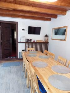 a large wooden table and chairs in a room at Casa Danci II in Borşa