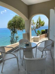 a patio with a table and chairs and the ocean at Beautiful House in Front of the Sea in Gázion