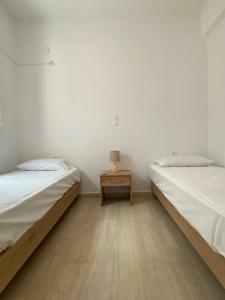 twee bedden in een kamer met een bijzettafel bij Beautiful House in Front of the Sea in Gázion