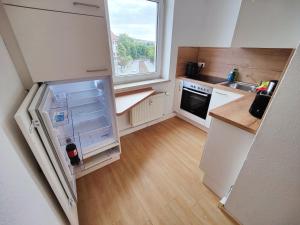 una pequeña cocina con nevera y ventana en YourFavoriteBed Designwohnung Nähe Zentrum und Klinikum, en Plauen