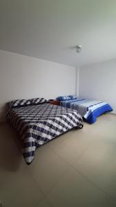 dos camas sentadas una al lado de la otra en una habitación en Apartamentos Turisticos EL ZIPA, en Zipaquirá