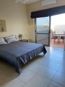 a bedroom with a bed and a view of a patio at Newly Refurbished Mellieha Central apartment in Mellieħa