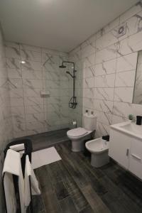 a bathroom with two toilets and a shower and a sink at Casinha da Alegria in Nordeste