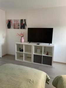 un centro de entretenimiento blanco con TV de pantalla plana en - SANO Apartments - bei Uwe, en Hagen