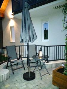 an umbrella and a table and chairs on a balcony at Sakura Apartment in Mosonmagyaróvár
