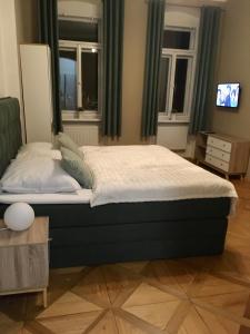 a large bed in a room with windows at Apartment Vertigo in Karlovy Vary