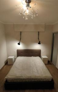 una camera da letto con un grande letto e un lampadario a braccio di Appartamento indipendente in Franciacorta a Passirano