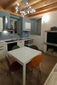 una cucina con tavolo e sedie bianchi di Appartamento indipendente in Franciacorta a Passirano