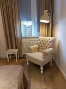 Pokój z krzesłem, lampką i oknem w obiekcie Apartament Prima w Lubniewicach