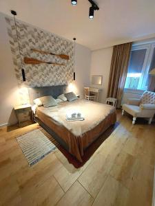 a large bedroom with a large bed and a couch at Apartament Prima in Lubniewice