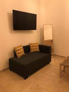 - un canapé noir dans le salon doté d'une télévision à écran plat dans l'établissement Casa di zia Pupetta, à Bari